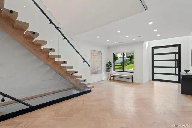 a view of an empty room with stairs and a window