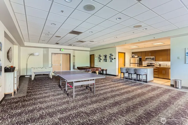 a living room with furniture a table and kitchen view