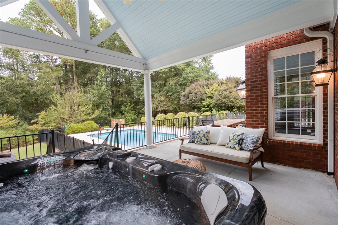 1104 Harpers Way Anderson, SC 29621 - Photo 37 of 50 Relax in the hot tub or gather on the patio overlooking the serene pool and lush greenery.
