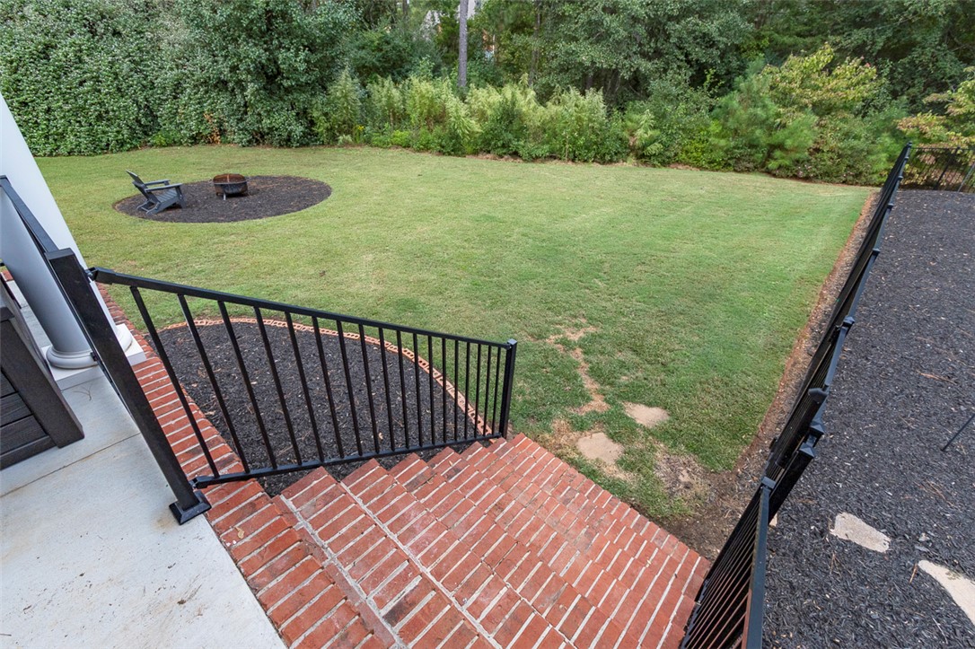 1104 Harpers Way Anderson, SC 29621 - Photo 42 of 50 This spacious backyard features a brick patio with stairs and ample green space for outdoor activities.