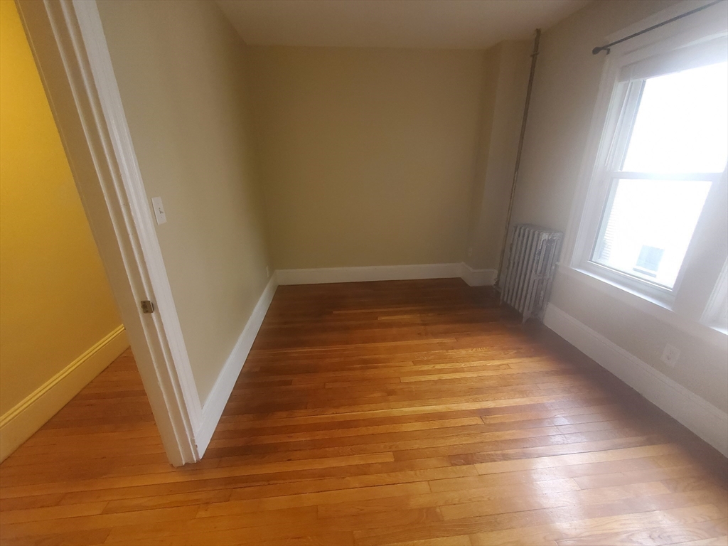 45 Intervale Street, Unit 2 Boston, MA 02121 - Photo 12 of 17 a view of an empty room with wooden floor and a window