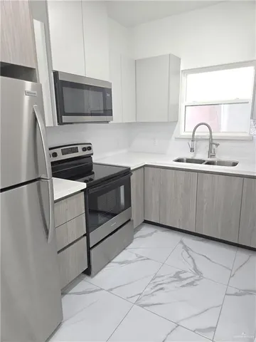 a kitchen with stainless steel appliances granite countertop a sink and a microwave