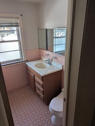 a bathroom with a toilet sink and mirror