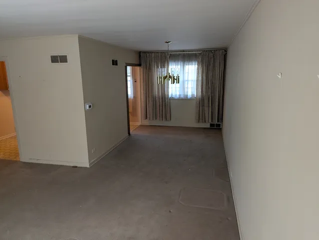 a view of an empty room with windows and bathroom