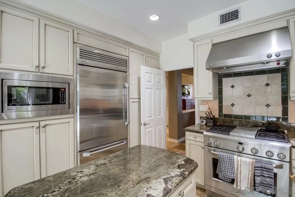 2305 Falkirk Row La Jolla, CA 92037 - Photo 14 of 36 a kitchen with stainless steel appliances granite countertop a stove and a refrigerator