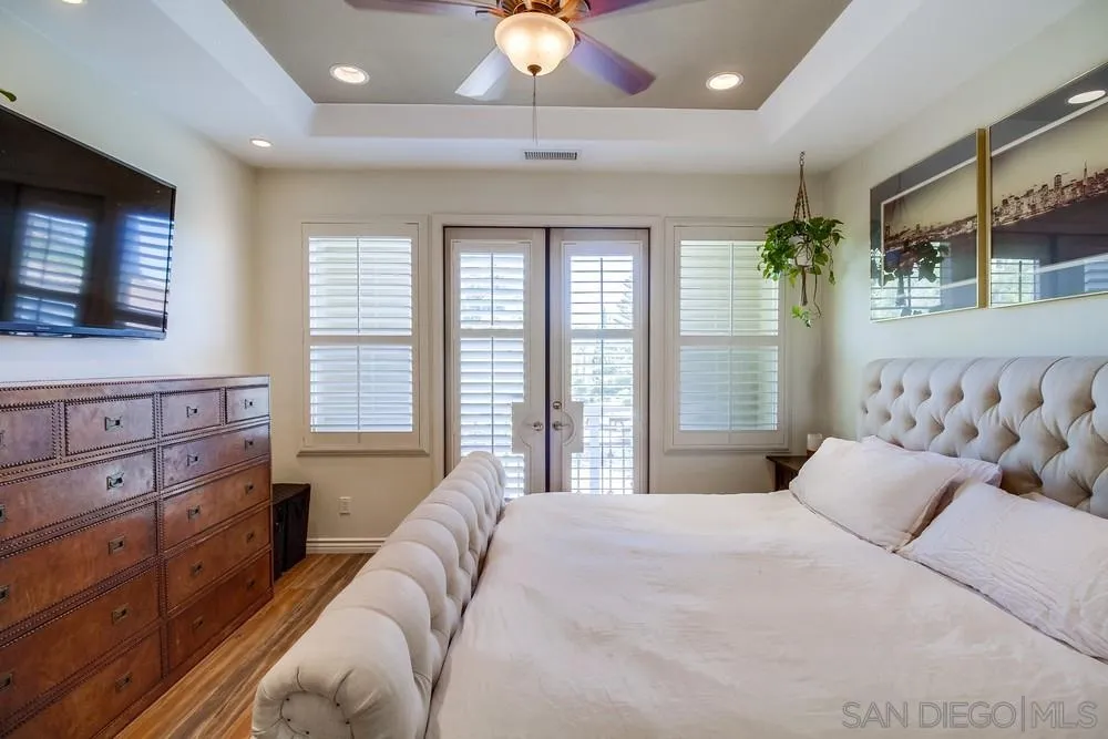 2305 Falkirk Row La Jolla, CA 92037 - Photo 32 of 36 a spacious bedroom with a bed and a chandelier