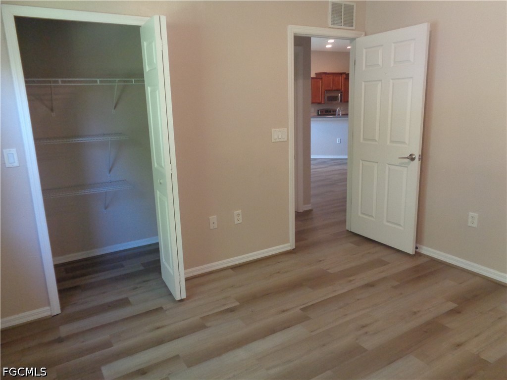 2463 Nature Pointe Loop Fort Myers, FL 33905 - Photo 32 of 50 an empty room with wooden floor and entrance