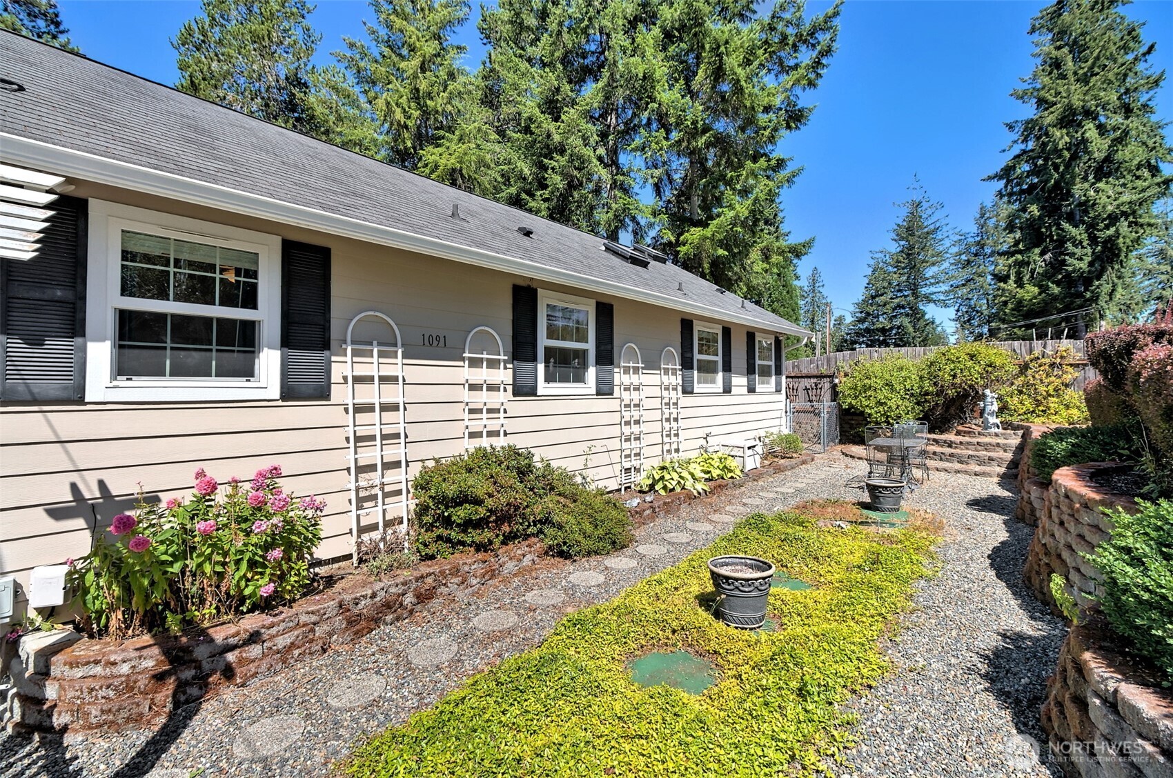 1091 E Trail Belfair, WA 98528 - Photo 4 of 31 a front view of a house with swimming pool and glass windows