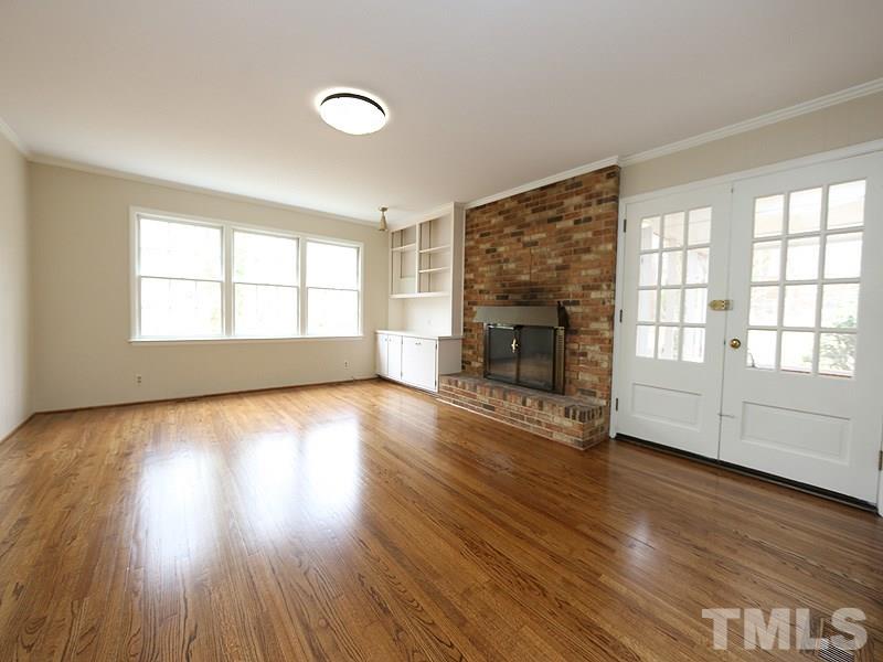 3412 Noel Court Raleigh, NC 27607 - Photo 7 of 25 an empty room with wooden floor and fireplace