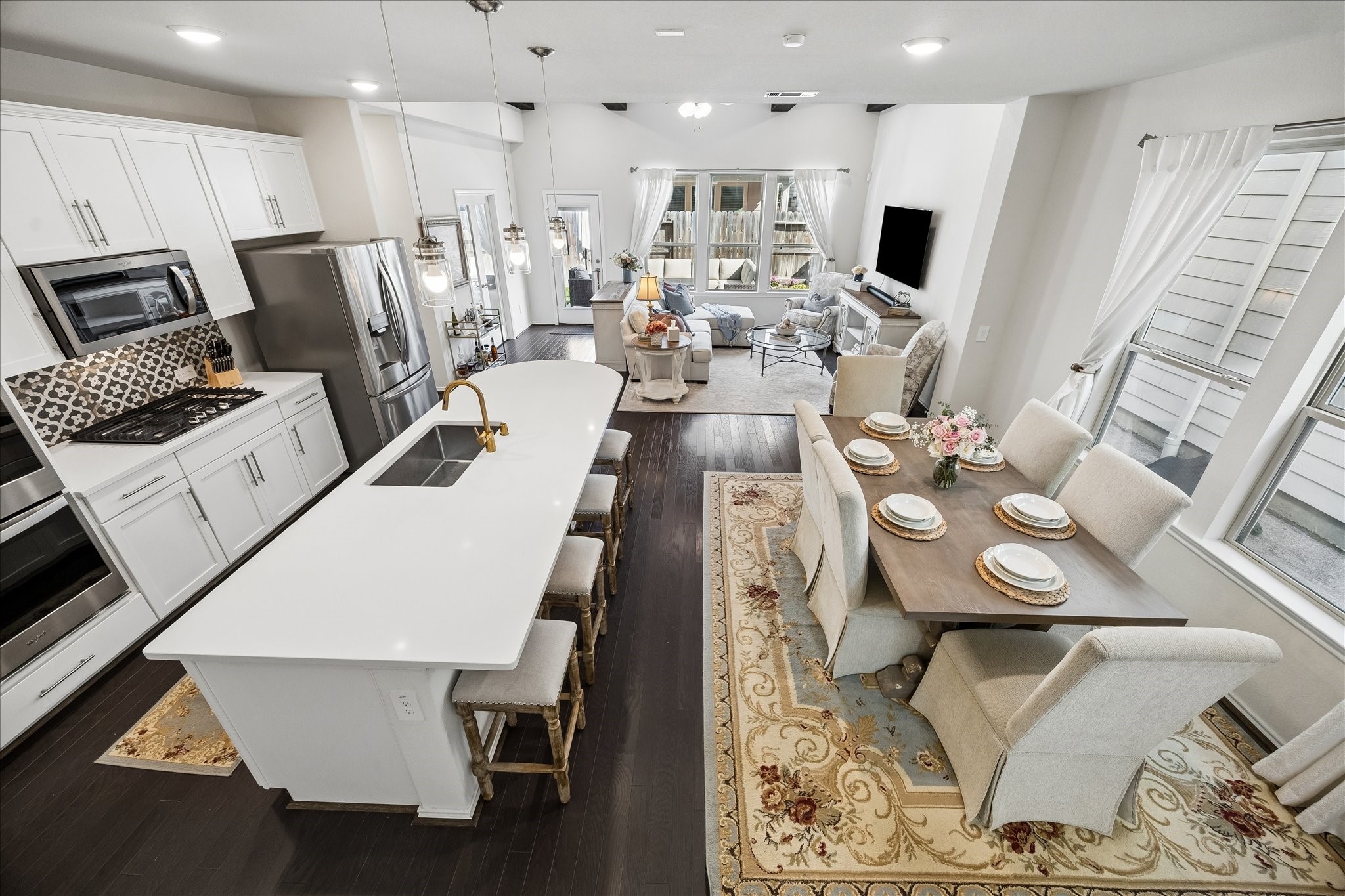 4026 Delta Rose Street Houston, TX 77018 - Photo 7 of 44 Open concept living featuring oversized island and bar seating, stainless appliances and custom cabinetry that flows into the dining and living areas with charcoal oak floors throughout, beam accents and views of the backyard.