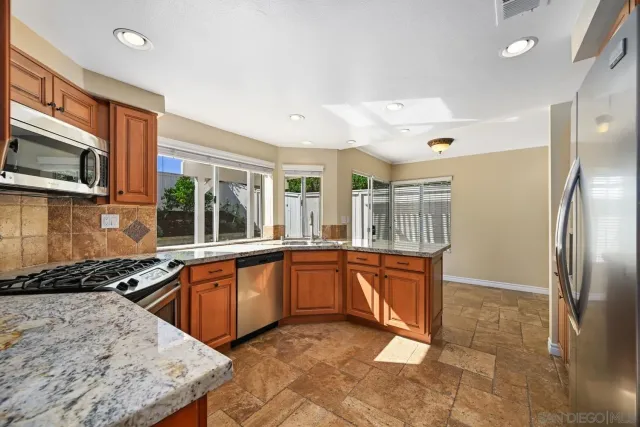 a kitchen with stainless steel appliances granite countertop a sink stove and refrigerator