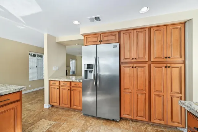 a kitchen with stainless steel appliances granite countertop a refrigerator and a sink