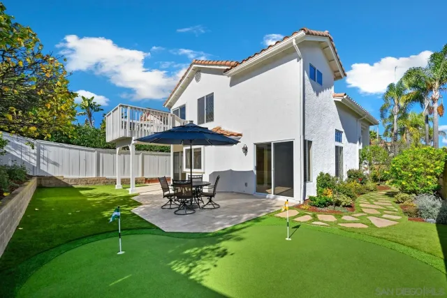 a view of a patio with table and chairs under an umbrella