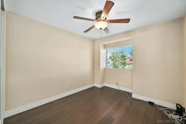 an empty room with a window and a ceiling fan