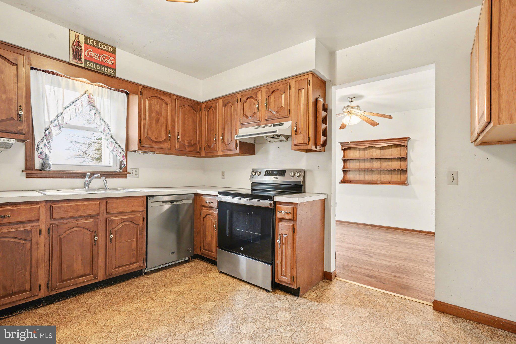 711 West Siddonsburg Road Dillsburg, PA 17019 - Photo 8 of 26 a kitchen with stainless steel appliances granite countertop a stove a sink and a refrigerator with wooden cabinets