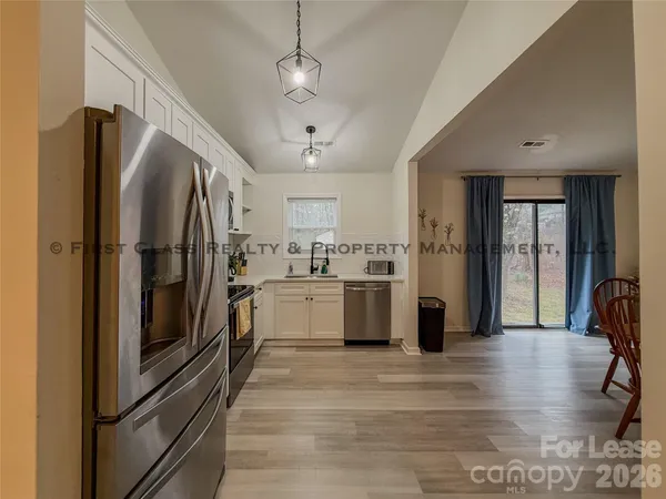 a kitchen with stainless steel appliances granite countertop a refrigerator a stove and a sink