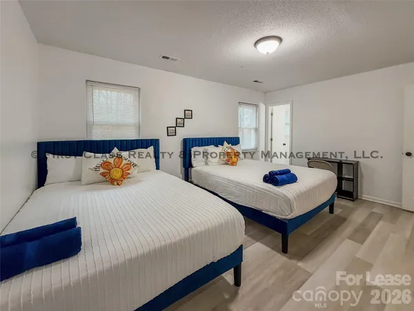 a bedroom with two beds and a dresser