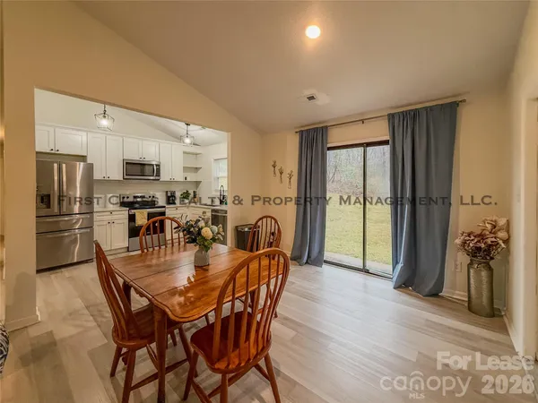 a dining room with furniture and a floor to ceiling window