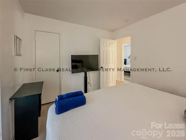 a bedroom with a bed and a flat screen tv