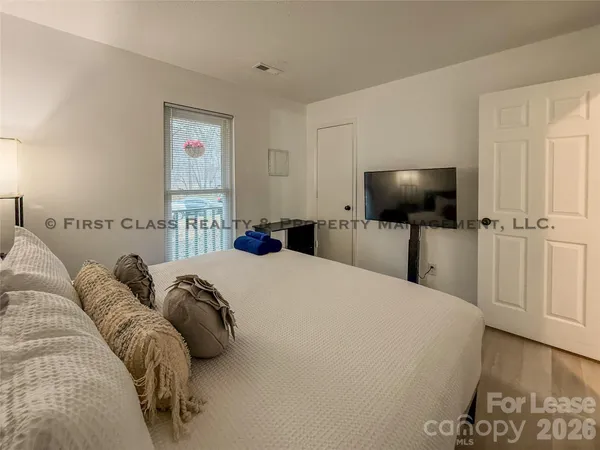 a bedroom with a bed and a flat screen tv