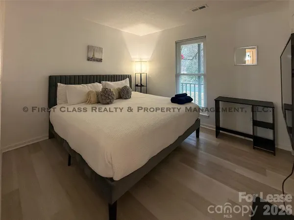 a bed sitting in a bedroom next to a window