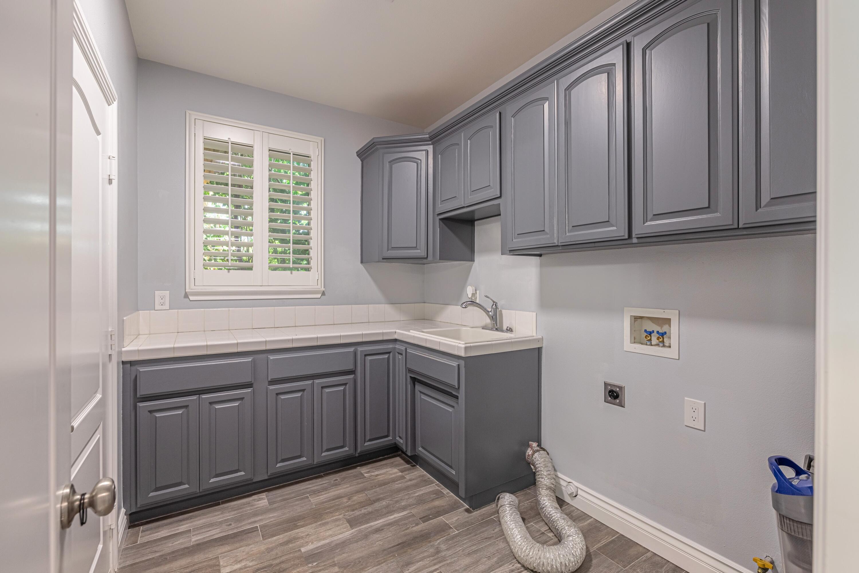 4023 Derby Circle Lancaster, CA 93536 - Photo 30 of 53 a kitchen with a sink cabinets and wooden floor