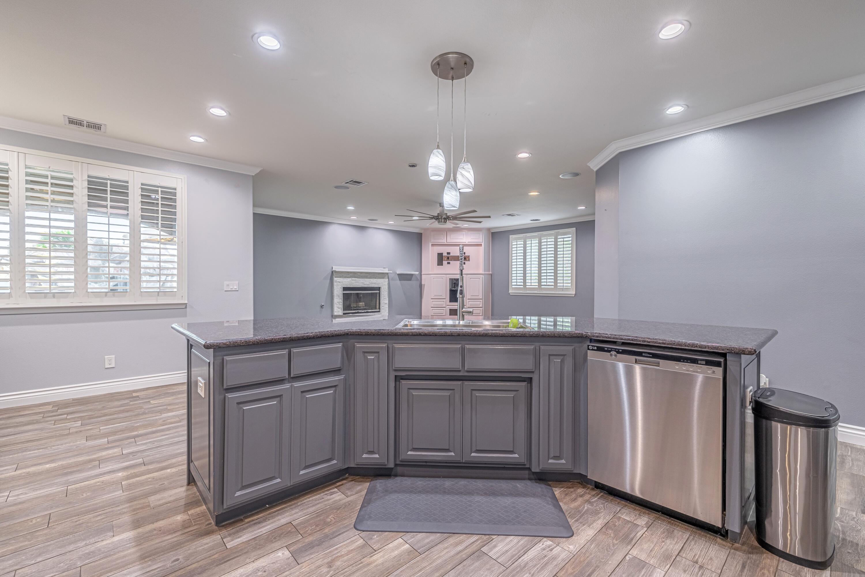 4023 Derby Circle Lancaster, CA 93536 - Photo 6 of 53 a large kitchen with granite countertop a sink and dishwasher a stove with wooden floor