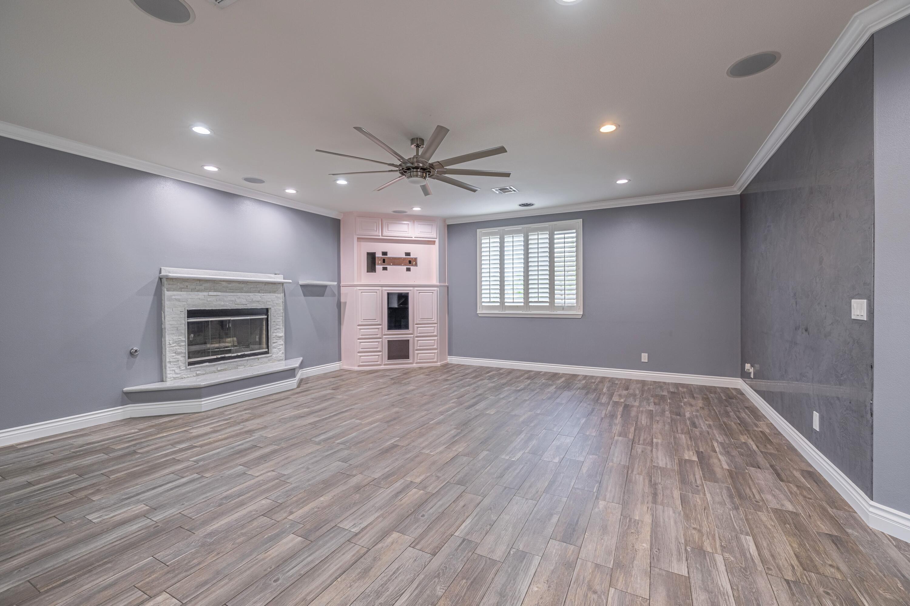 4023 Derby Circle Lancaster, CA 93536 - Photo 7 of 53 an empty room with wooden floor fireplace and windows