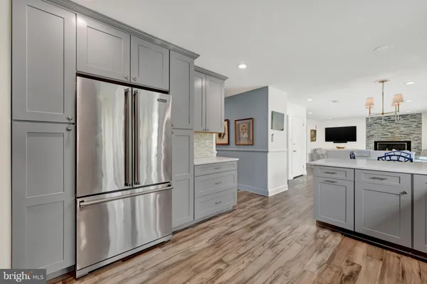 a kitchen with cabinets stainless steel appliances and wooden floor