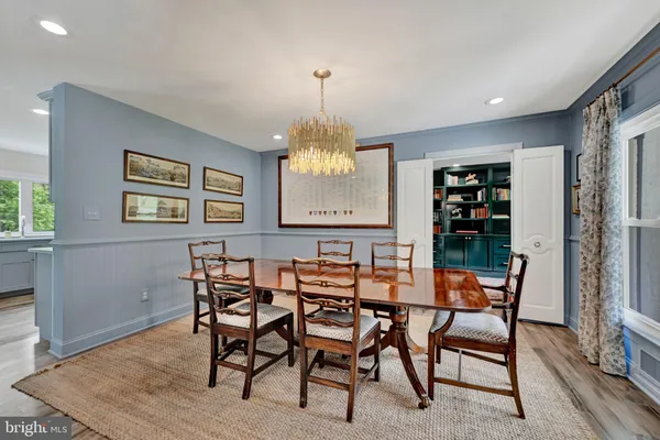 a dining room with furniture a chandelier and window