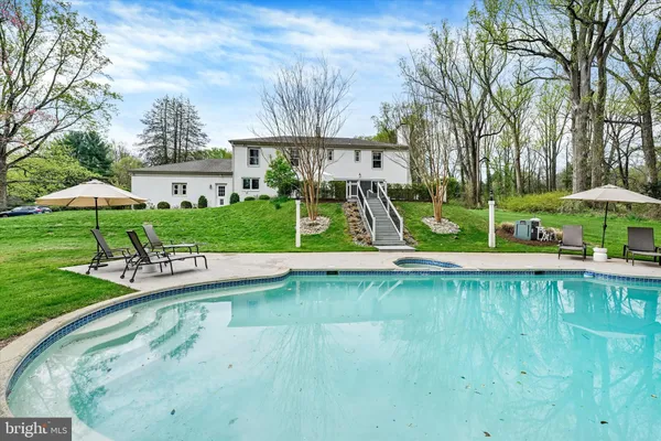 a view of a swimming pool with a patio and a yard