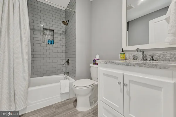 a bathroom with a granite countertop sink toilet and shower