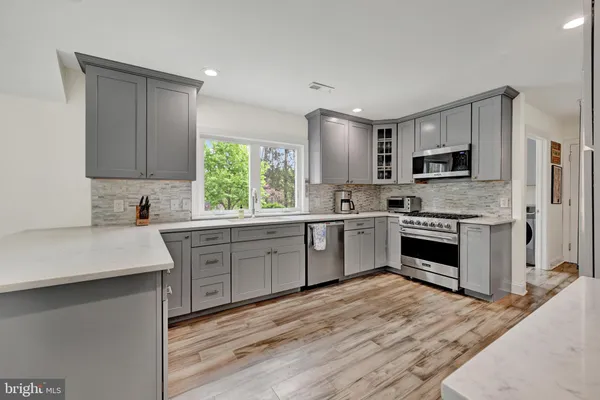 a kitchen with stainless steel appliances white cabinets a sink and a stove