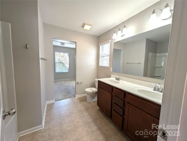 a spacious bathroom with a granite countertop sink mirror and a toilet