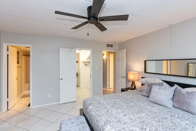 a bedroom with a bed mirror and window