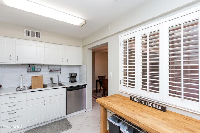 a kitchen with granite countertop a sink and white cabinets