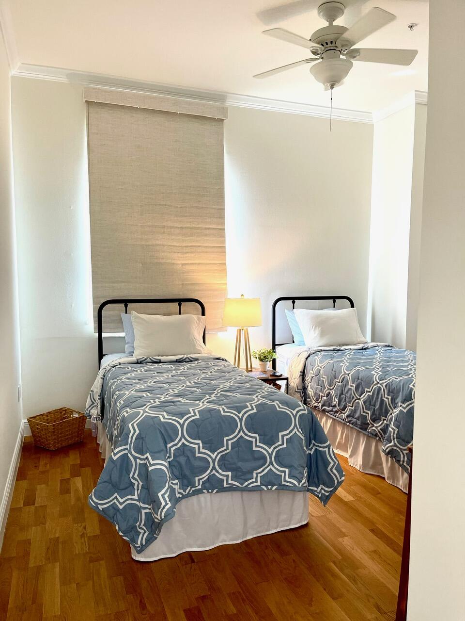 255 Evernia Street, Unit 407 West Palm Beach, FL 33401 - Photo 24 of 31 a bedroom with two beds and a chandelier