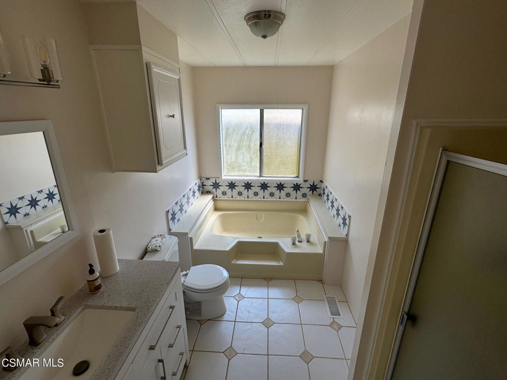 24303 Woolsey Canoga Park, Unit 26 Los Angeles, CA 90068 - Photo 15 of 28 a bathroom with a granite countertop sink mirror vanity and toilet