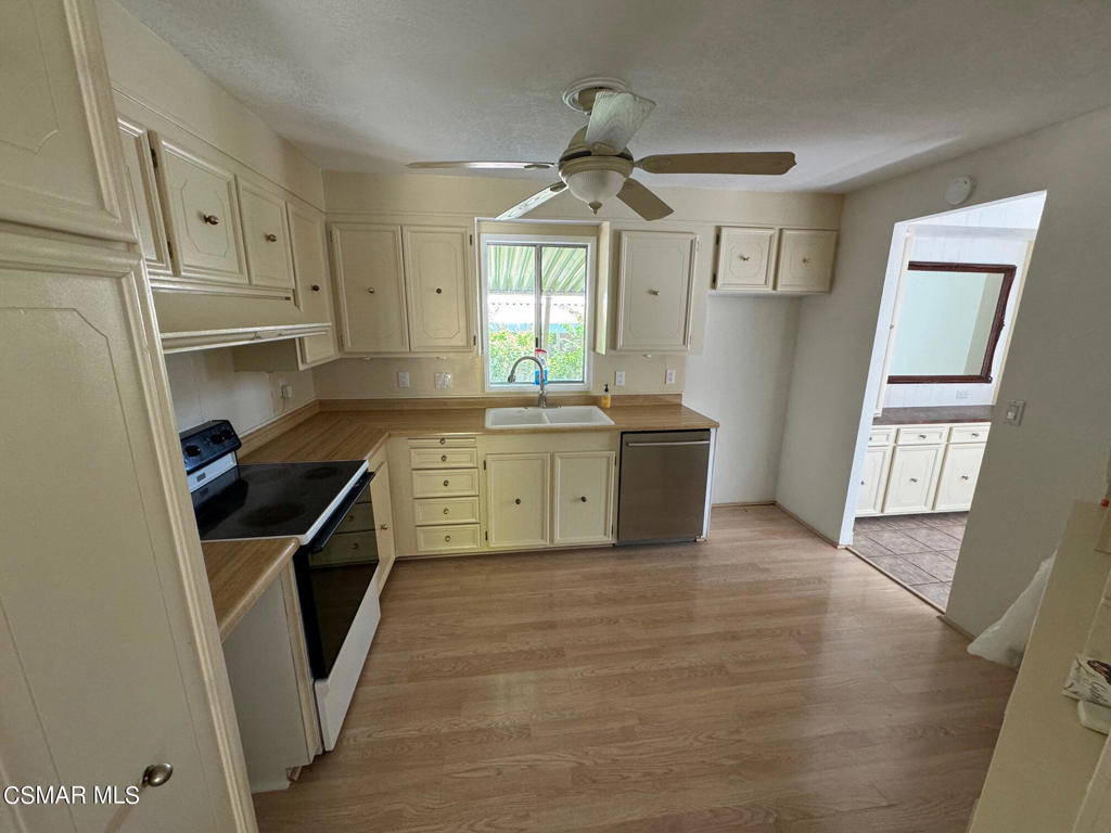 24303 Woolsey Canoga Park, Unit 26 Los Angeles, CA 90068 - Photo 8 of 28 a kitchen with stainless steel appliances granite countertop a sink stove and refrigerator