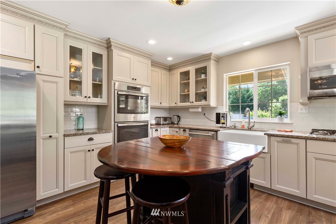 9451 Avon Allen Road Bow, WA 98232 - Photo 16 of 40 a kitchen with stainless steel appliances granite countertop a stove a refrigerator a sink a dining table and chairs