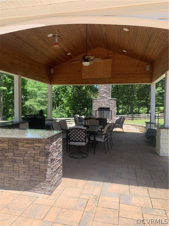 20710 River Road Chesterfield, VA 23838 - Photo 21 of 24 a view of a patio with dining table and chairs under an umbrella with a barbeque