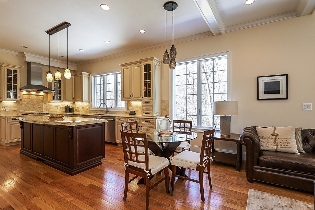 17 Drew Road Newton, MA 02467 - Photo 9 of 22 a kitchen with stainless steel appliances kitchen island granite countertop a stove a sink a dining table and chairs with wooden floor