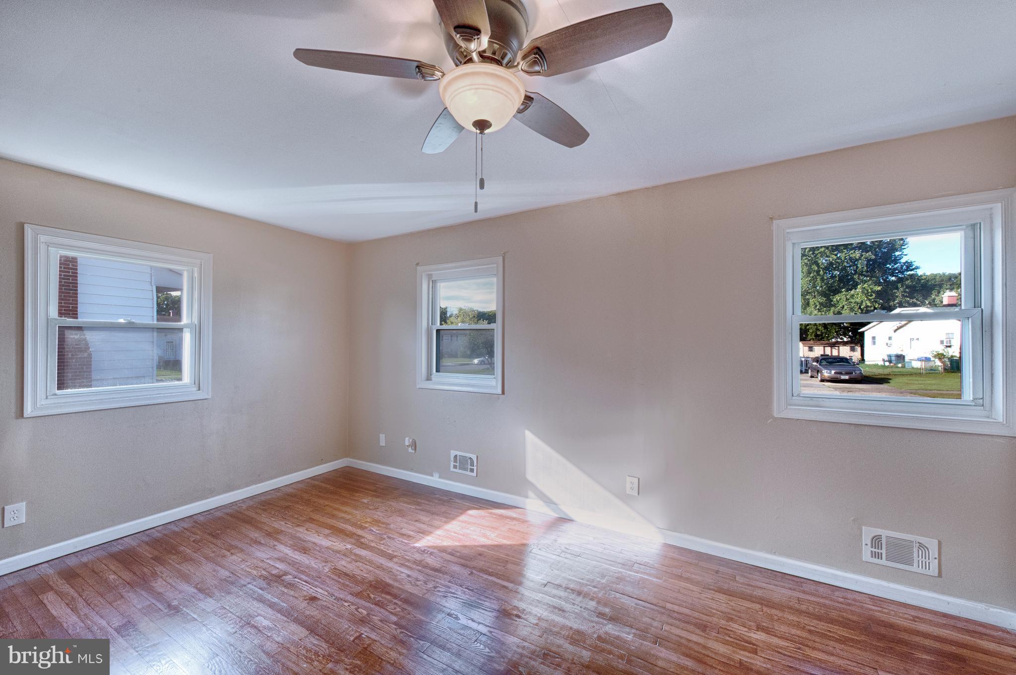 529 Crisfield Road Baltimore, MD 21220 - Photo 13 of 19 a view of an empty room with wooden floor and a window