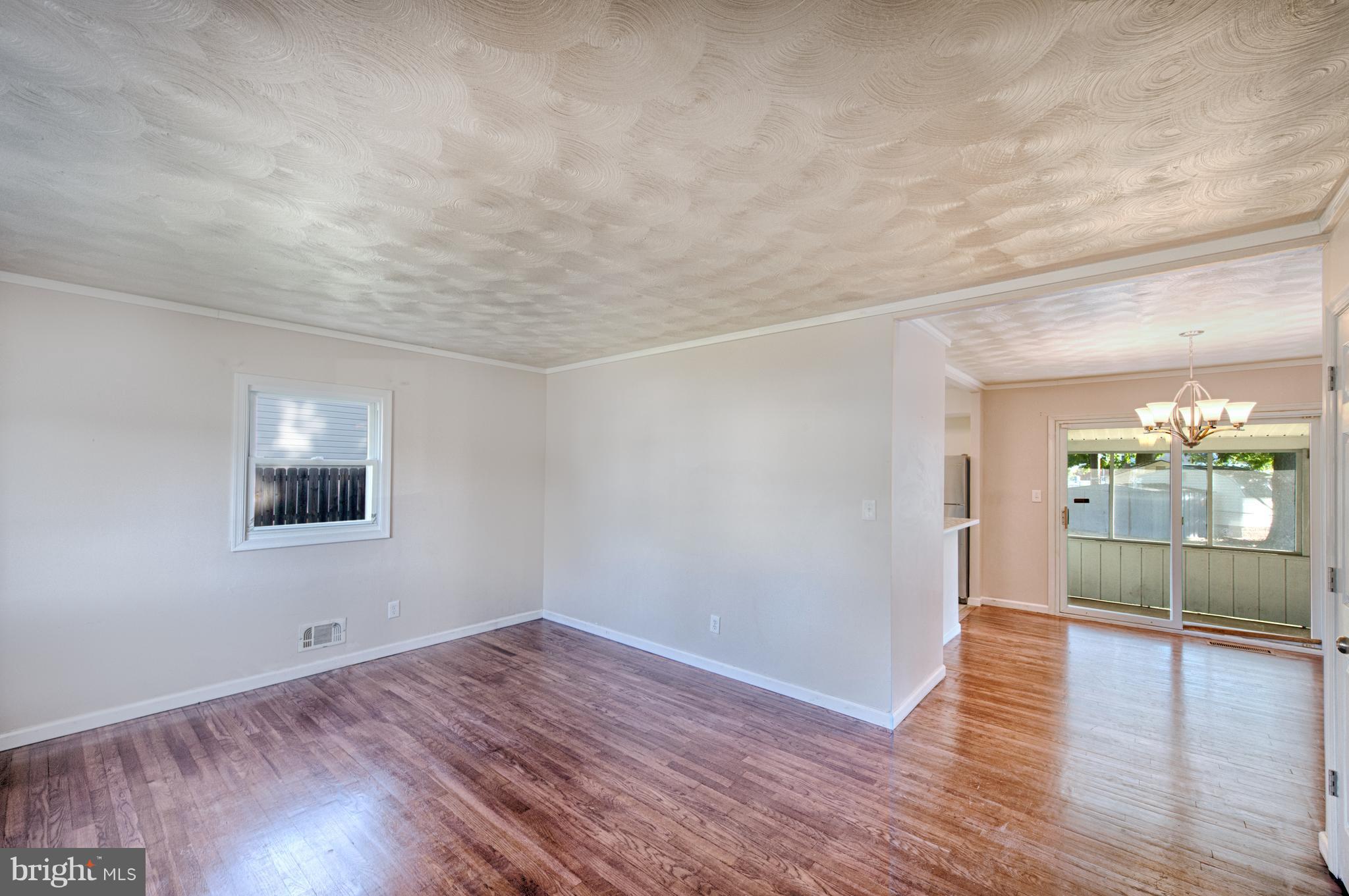 529 Crisfield Road Baltimore, MD 21220 - Photo 4 of 19 an empty room with wooden floor and windows