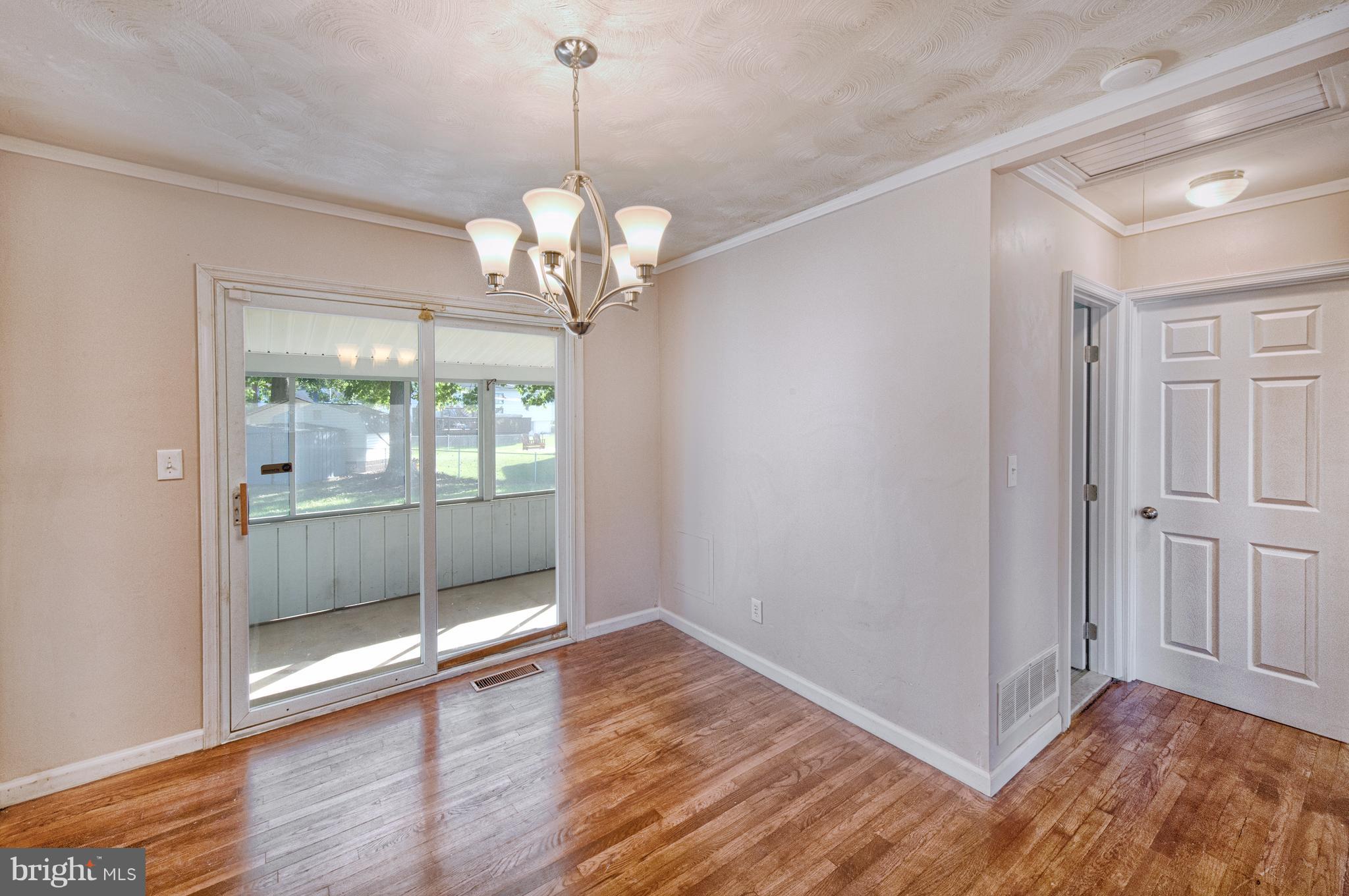 529 Crisfield Road Baltimore, MD 21220 - Photo 5 of 19 a view of a livingroom with wooden floor and a chandelier