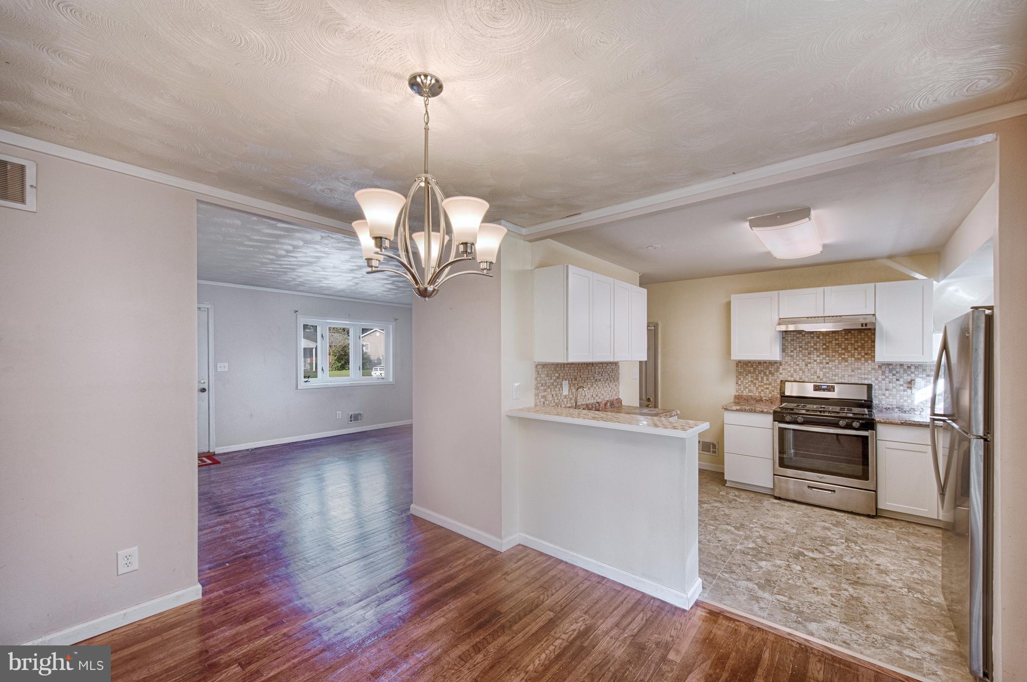 529 Crisfield Road Baltimore, MD 21220 - Photo 6 of 19 a open kitchen with stainless steel appliances granite countertop a refrigerator a stove a sink dishwasher a oven with white cabinets and wooden floor