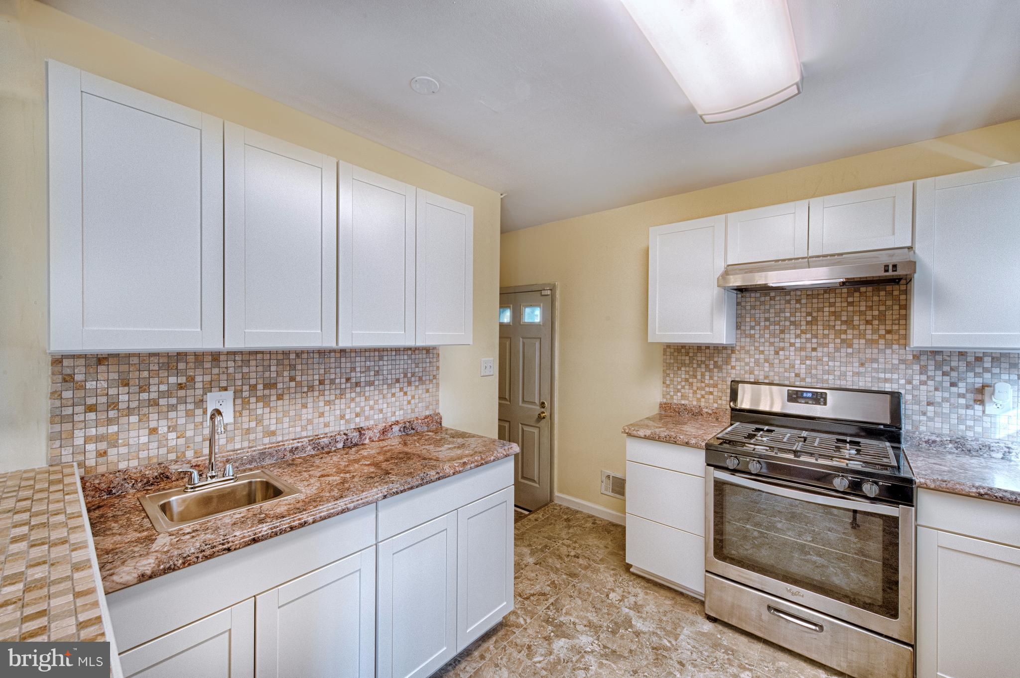 529 Crisfield Road Baltimore, MD 21220 - Photo 9 of 19 a kitchen with granite countertop a sink a stove and cabinets