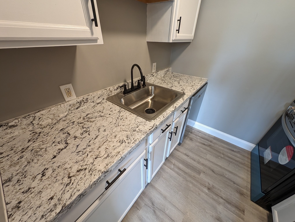 191 Glasgow Street, Unit 3 Fall River, MA 02721 - Photo 4 of 16 a kitchen with wooden floor and a sink