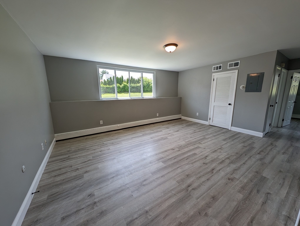 191 Glasgow Street, Unit 3 Fall River, MA 02721 - Photo 6 of 16 an empty room with wooden floor and windows