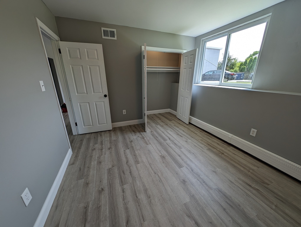 191 Glasgow Street, Unit 3 Fall River, MA 02721 - Photo 10 of 16 an empty room with wooden floor and windows